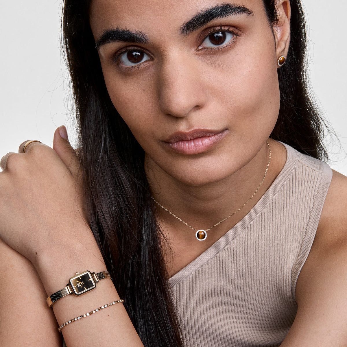 Woman wearing Audrey Necklace Tiger Eye Gold with domed Tiger Eye pendant and cubic zirconia, styled for everyday elegance.