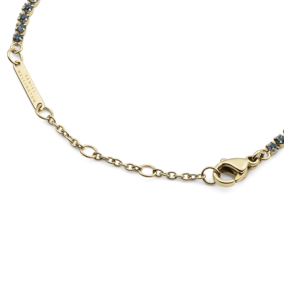 Close-up of the Classic Tennis Bracelet Nightfall Gold, highlighting the adjustable gold chain, secure lobster clasp, and individually set dark Preciosa crystals.