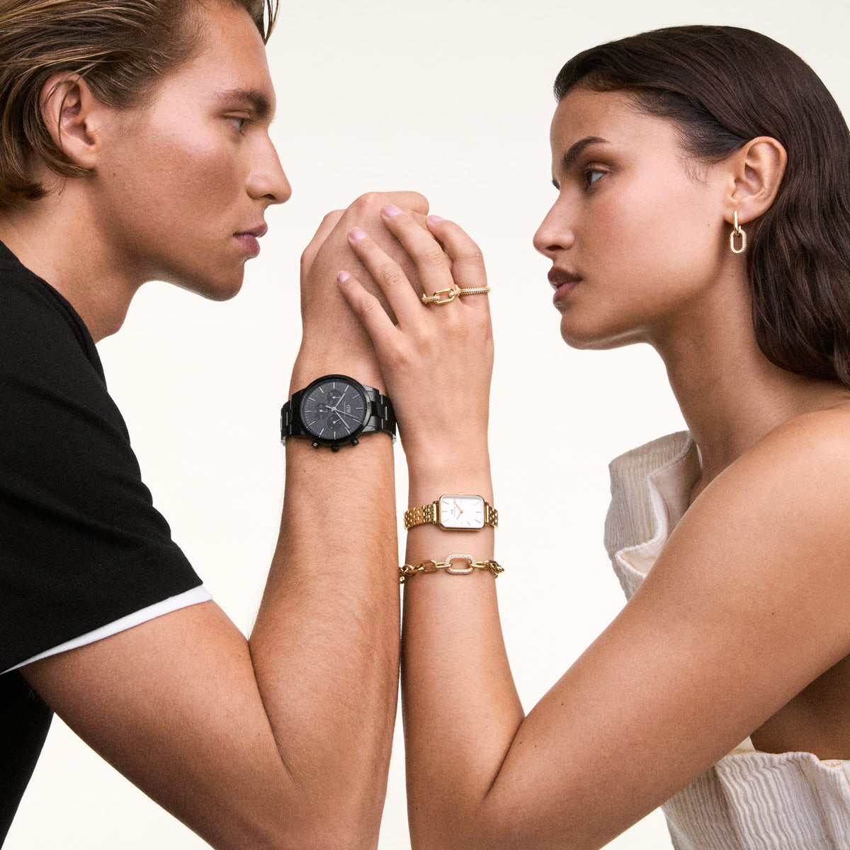 Woman wearing Quadro 5-Link Evergold gold watch with rectangular dial, styled with gold bracelet and ring, arm-in-arm with man.