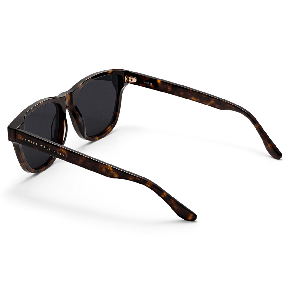 Ambler Bio-Acetate Dark Havana sunglasses with a tortoiseshell frame, black lenses, and Daniel Wellington branding on the arm, shown from a rear angle to highlight the lightweight, curved design.