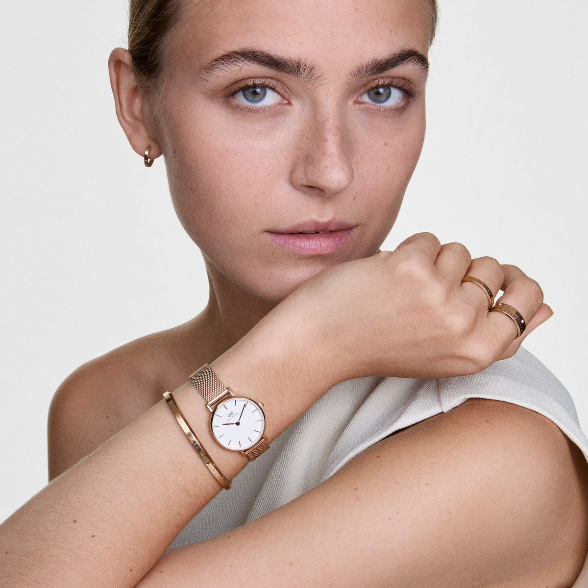 Woman wearing the Classic Ring Rose Gold on her finger, styled with a matching rose gold watch, bangle, and earrings for a coordinated, elegant look.