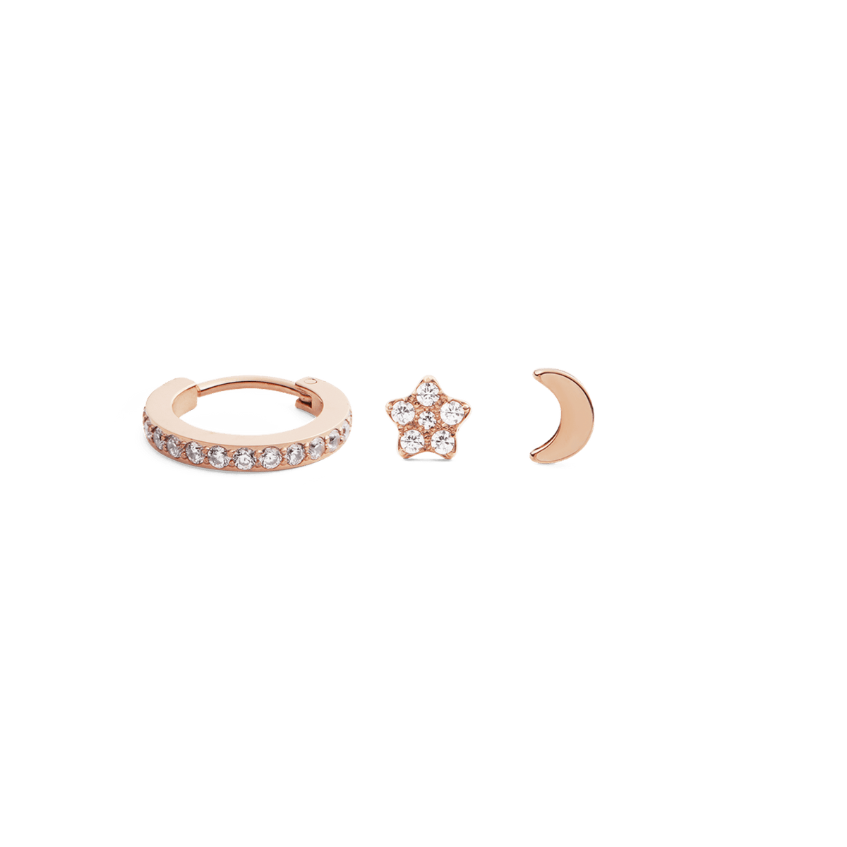 Rose gold earring set featuring a crystal-adorned hoop, a star-shaped stud with clear crystals, and a smooth crescent moon stud, all displayed against a plain background. The trio showcases a celestial theme with a refined, modern finish.