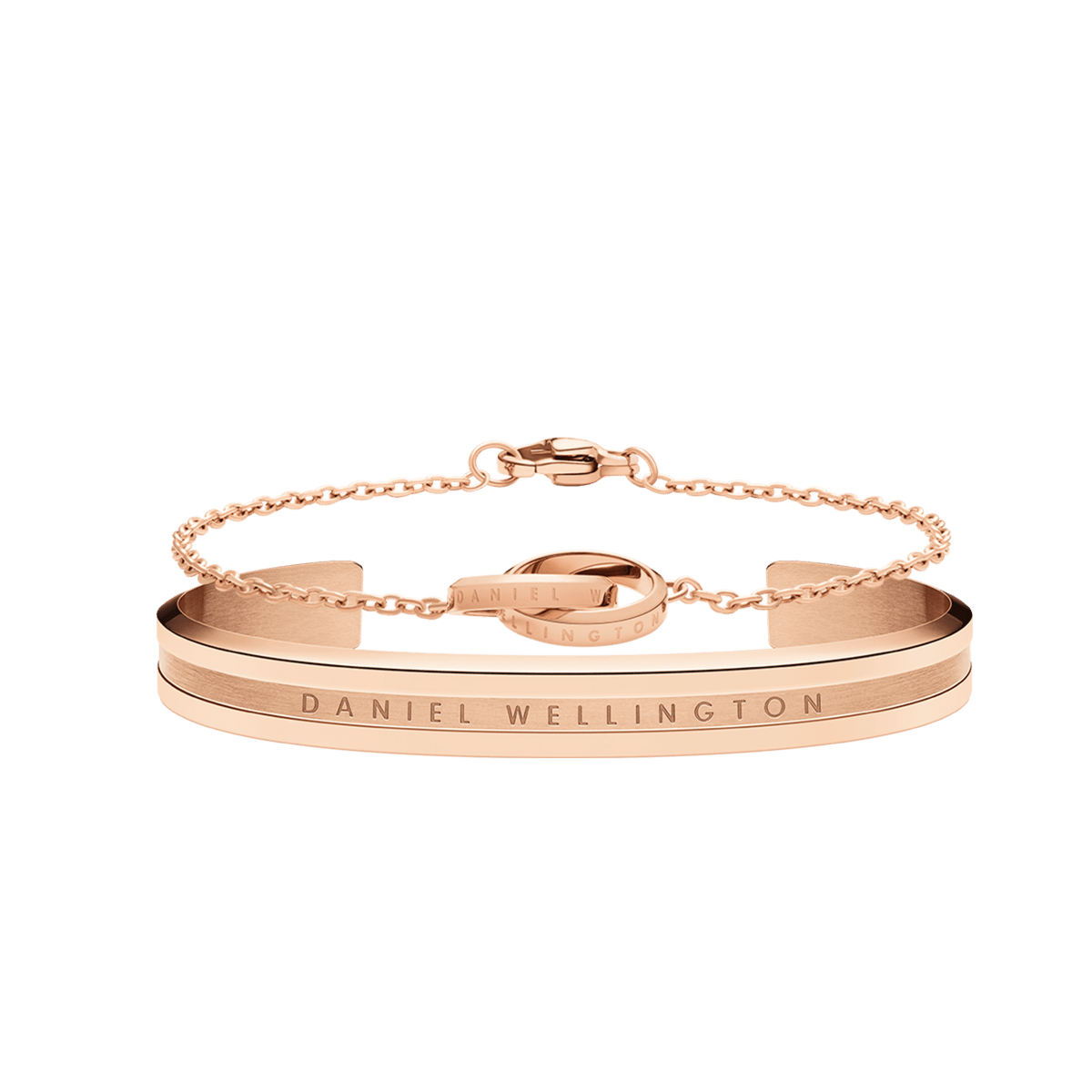 Rose gold bracelet set featuring a sleek cuff with engraved Daniel Wellington branding and a delicate chain bracelet, both designed for a refined, minimalist look.