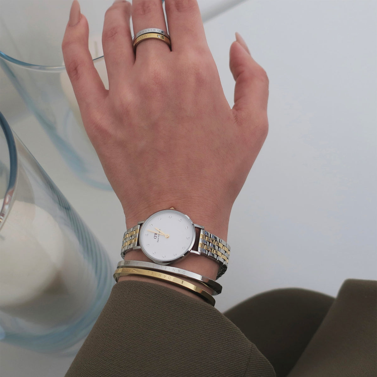 Petite Lumine 5-link two-tone women’s watch with a silver and gold bracelet and crystal-set dial, styled on the wrist alongside gold and silver bangles.