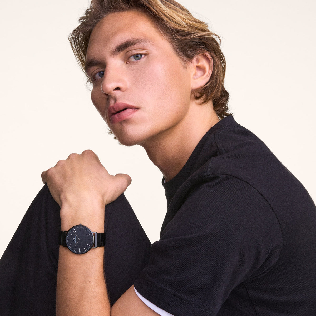 A man wearing the Classic Piano Link Graphite Unitone watch, showing its brushed graphite dial and matching piano link strap styled with a casual dark t-shirt.