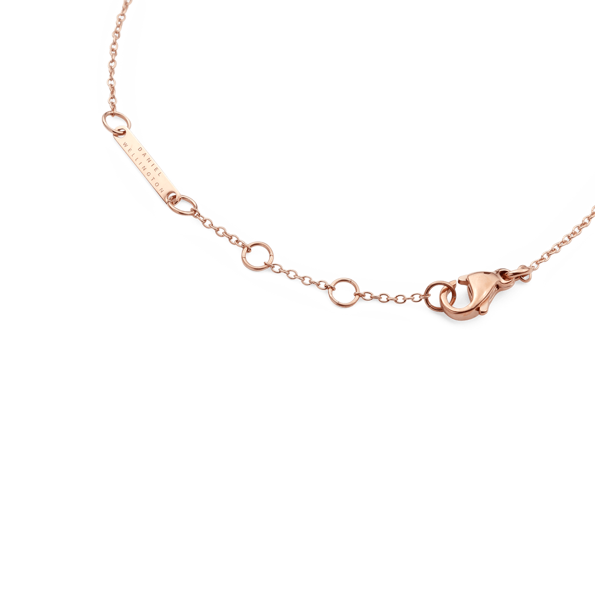 Close-up of the Crystal Zodiac Chain Bracelet Rose Gold showing the adjustable sizing rings, lobster clasp, and engraved Daniel Wellington tag.