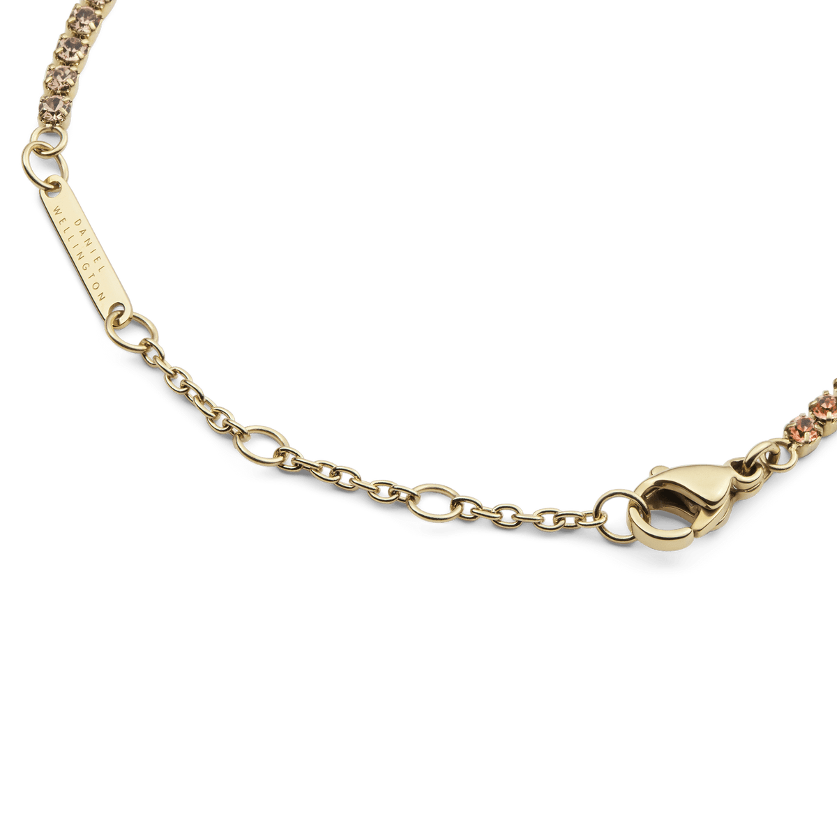 Detail of the Classic Tennis Bracelet Apricot Gold, highlighting the adjustable gold chain, secure lobster clasp, and Daniel Wellington branding next to apricot Preciosa crystals.