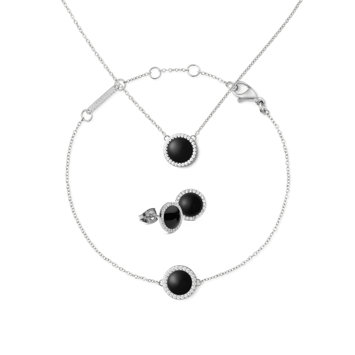 Silver jewellery set featuring a necklace, bracelet, and stud earrings, each with a round black agate centre surrounded by a halo of white crystals and set on fine silver chains. The pieces have a modern, minimalist design, ideal for both everyday wear and special occasions.