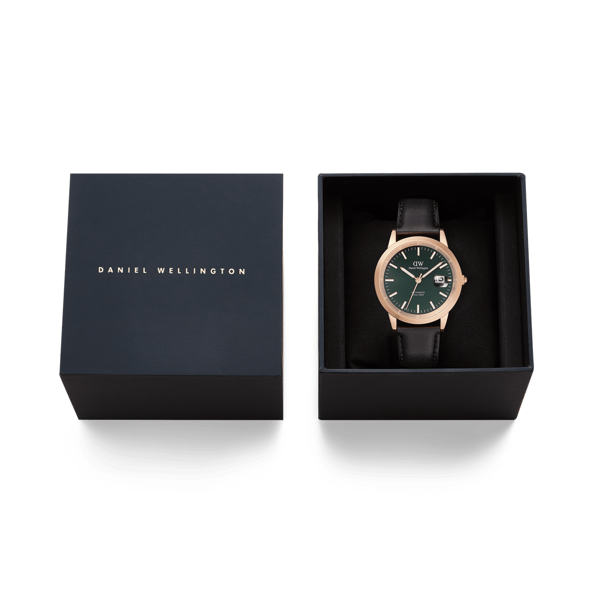 Daniel Wellington Iconic Sheffield Automatic Rose Gold watch with an emerald green dial and black leather strap, presented in an open signature gift box beside its matching lid.