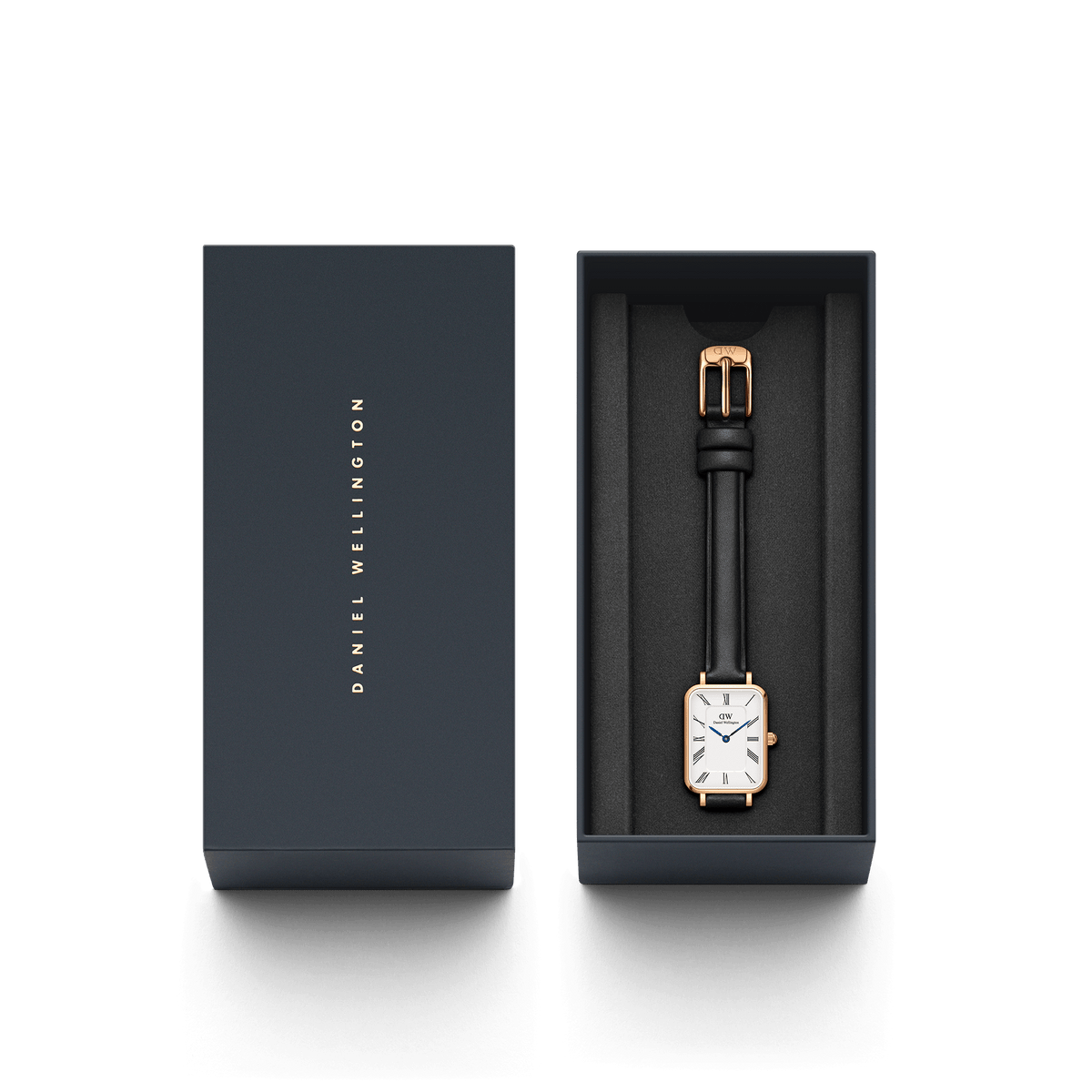 Quadro Roman Numerals Sheffield Rose Gold watch with a rectangular rose gold case and black leather strap, elegantly presented in a dark Daniel Wellington gift box.