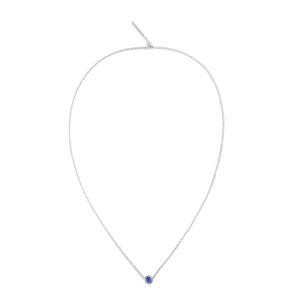 A fine S925 sterling silver chain necklace features a small round charm with a deep blue crystal at its centre.