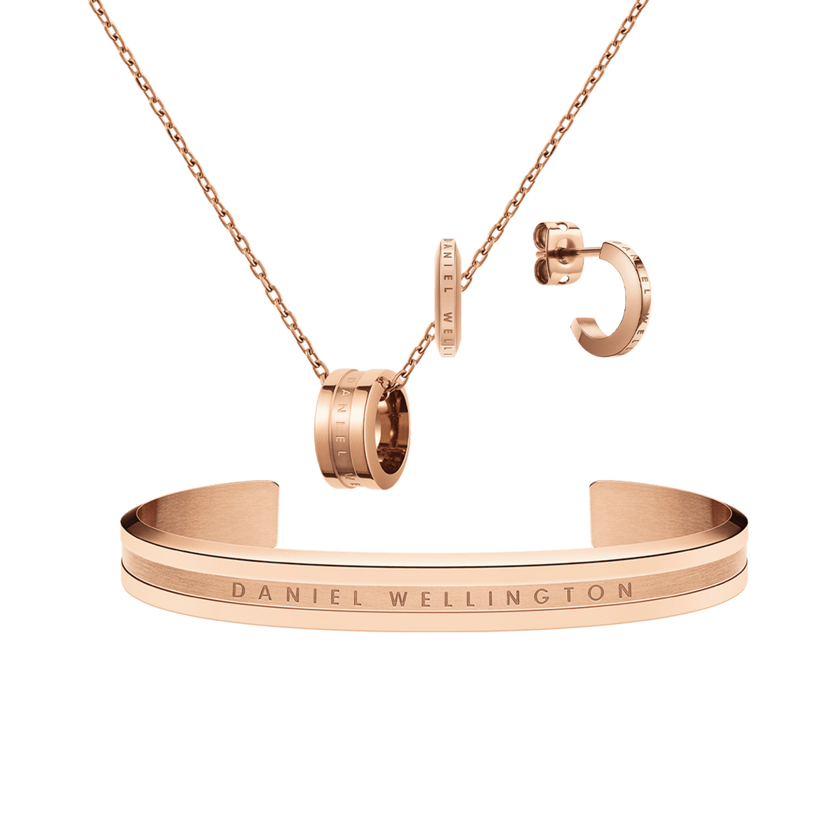 Rose gold jewellery set featuring a delicate chain necklace with a signature ring pendant, matching hoop earrings, and a sleek open cuff bracelet, each engraved with subtle Daniel Wellington branding. The coordinated pieces showcase a modern yet timeless design with a polished finish.