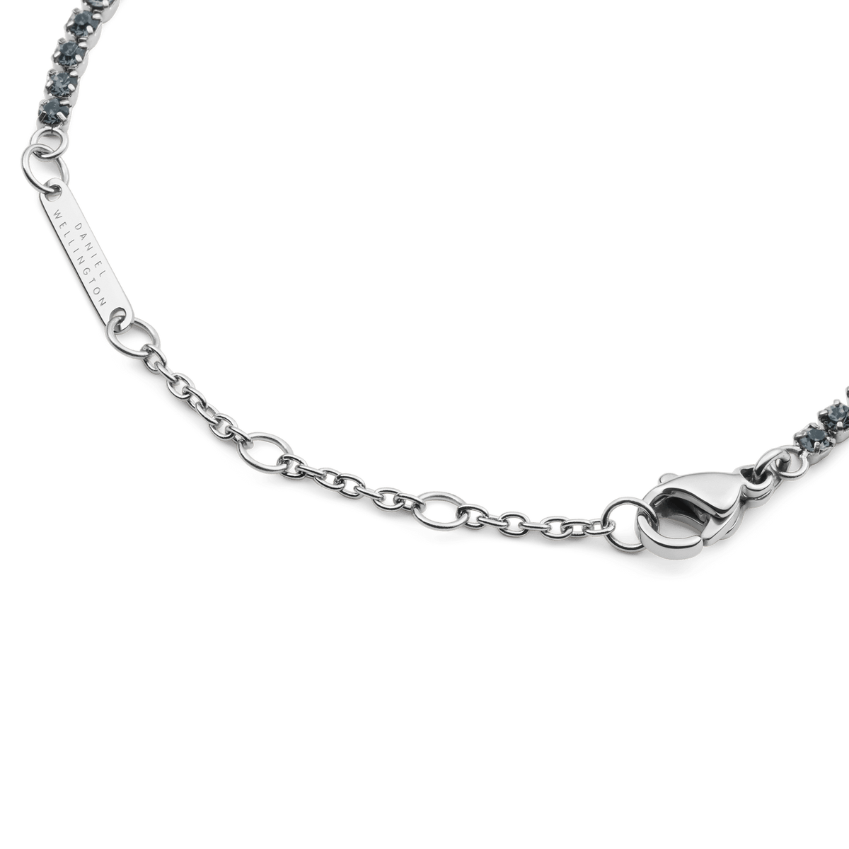 Detail view of the Classic Tennis Bracelet Nightfall Silver, highlighting the adjustable silver chain, secure lobster clasp, and Daniel Wellington engraved tag.