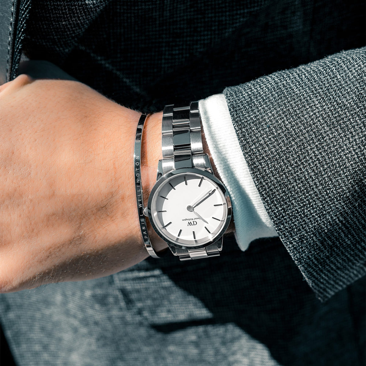 Daniel Wellington Iconic Link Silver watch with white dial, worn with a suit and paired with a matching silver bracelet.