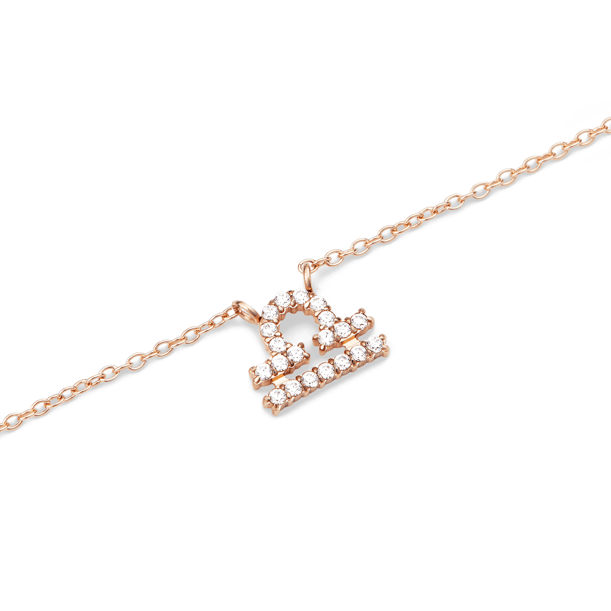 Close-up of a rose gold chain necklace featuring a Libra zodiac pendant adorned with sparkling hand-set crystals.