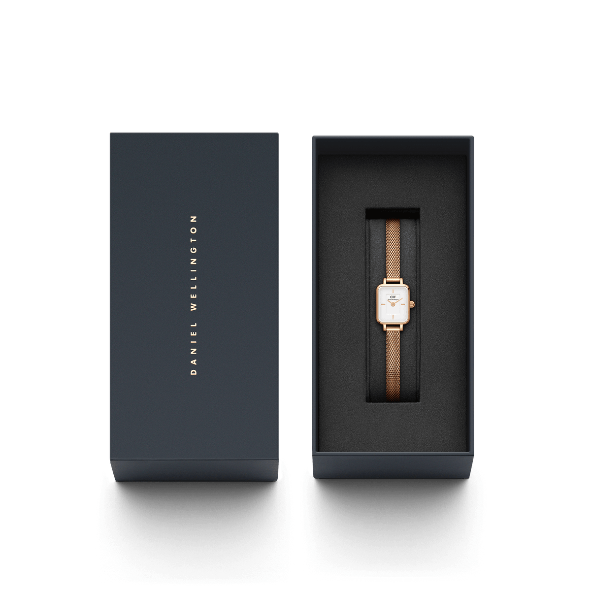 Quadro Mini Melrose women’s watch with a rectangular white dial and rose gold mesh strap, elegantly presented in a dark Daniel Wellington gift box.