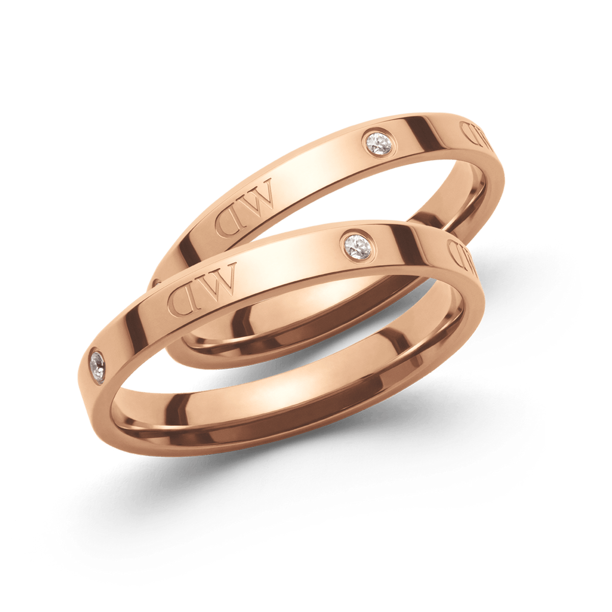 Pair of polished rose gold rings featuring sparkling stones and the Daniel Wellington engraving, showcasing a refined band design with a sophisticated, modern classic finish.