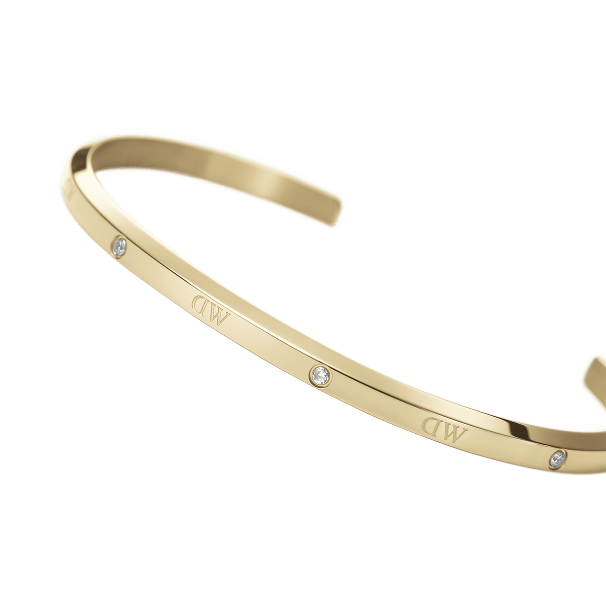 Elegant Classic Lumine Bracelet G in polished gold, featuring a slim open cuff design with six sparkling crystals and subtle DW engraving along the band.