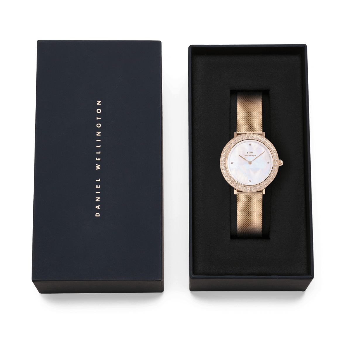 Crystalline Bezel Melrose women’s watch with a rose gold mesh strap and mother of pearl dial, elegantly presented in a black Daniel Wellington gift box.