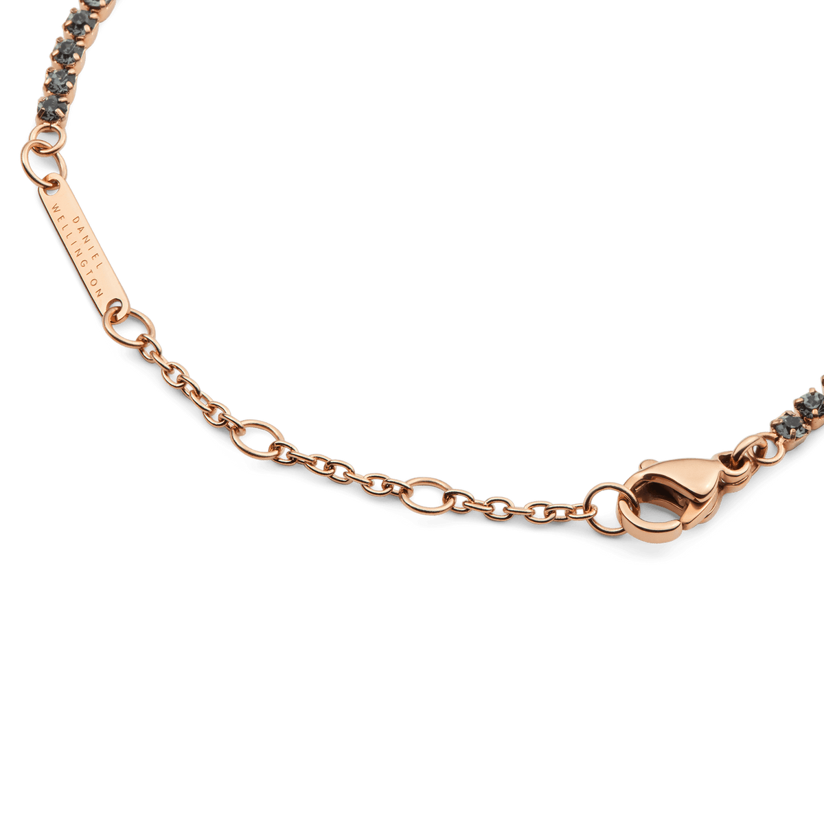 Detail of the Classic Tennis Bracelet Nightfall Rose Gold, showing the adjustable rose gold chain, secure lobster clasp, and Daniel Wellington engraved tag.