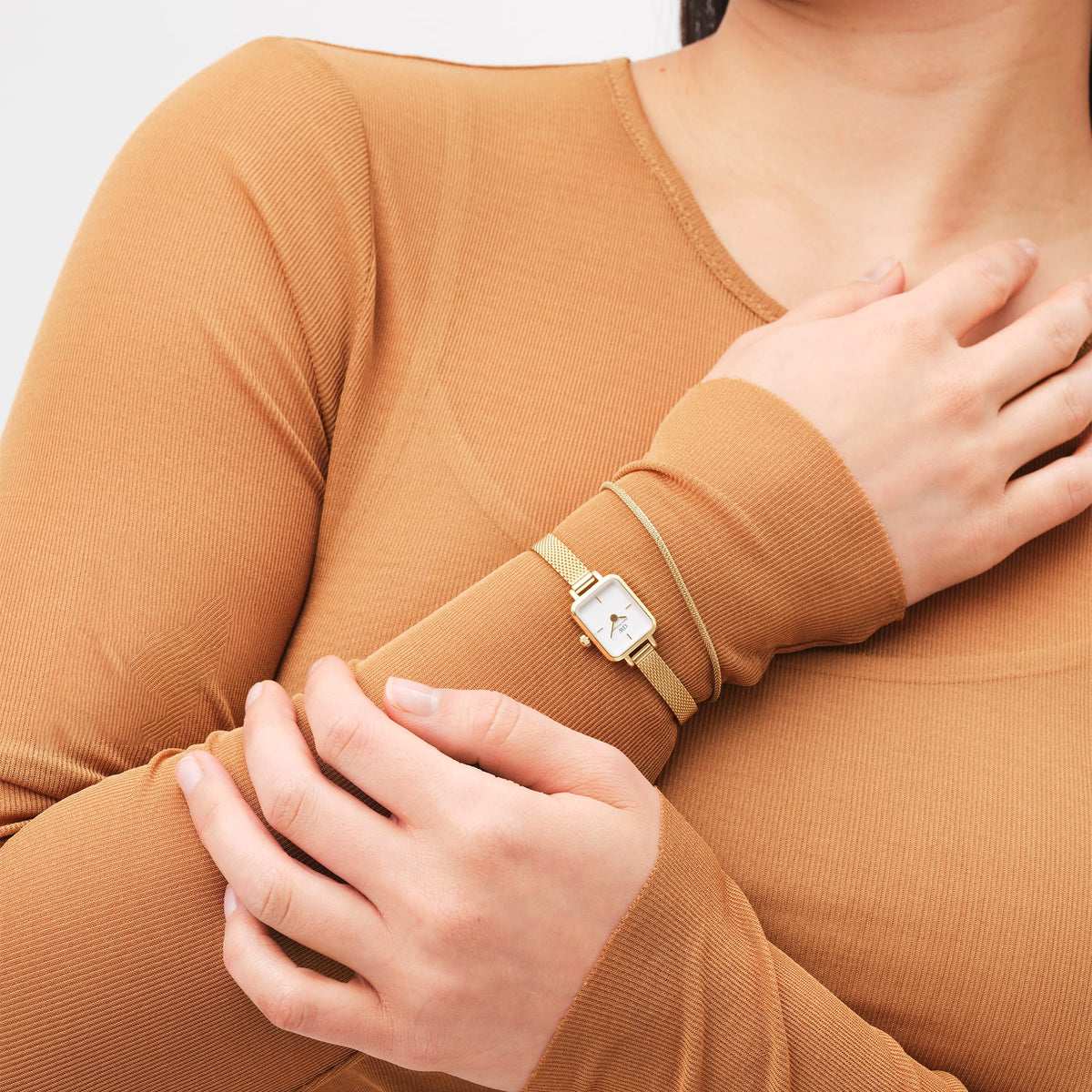 Quadro Mini Evergold petite gold mesh strap watch with white dial, styled on wrist for an elegant everyday look.