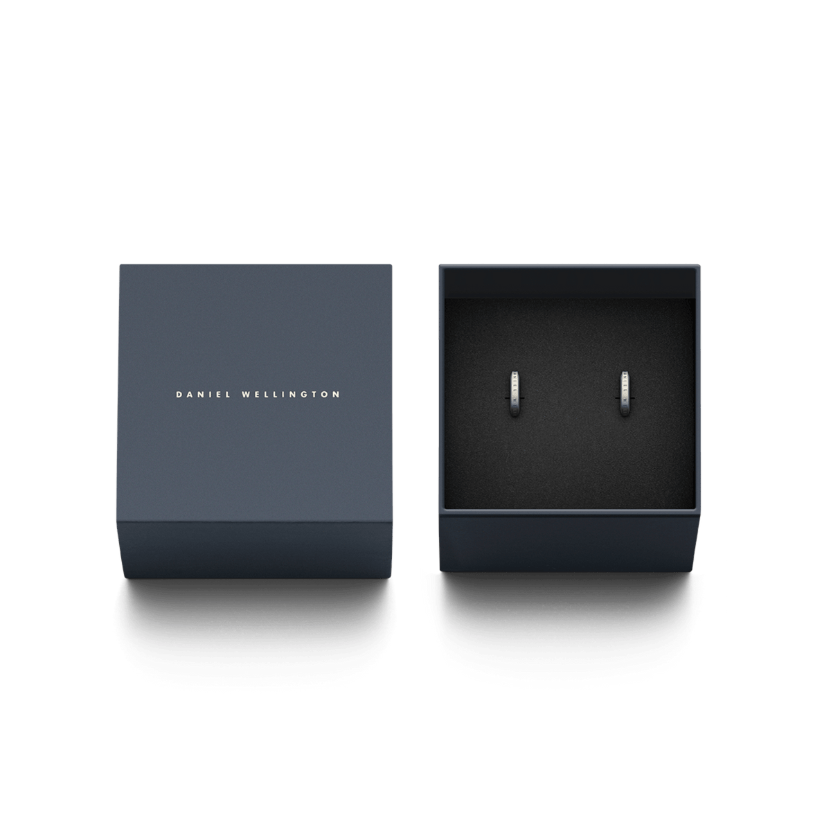 Elan Earrings Silver presented in a navy Daniel Wellington gift box, minimalist stainless steel huggie hoops with engraved detail.