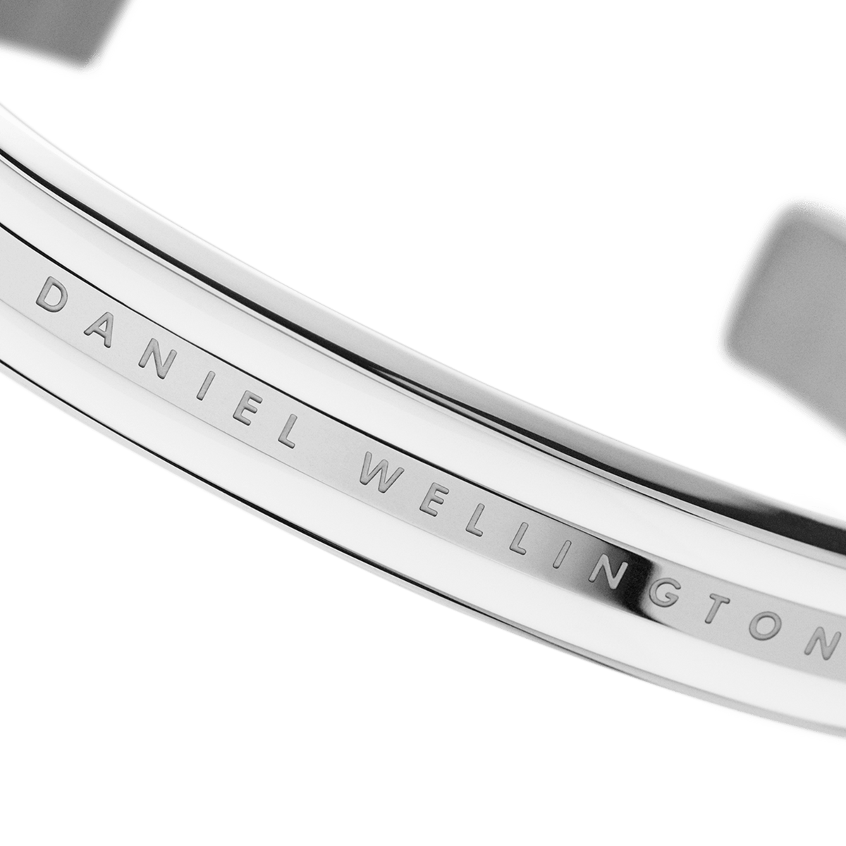 Detail view of the Daniel Wellington Emalie Bracelet showing the engraved logo on polished silver-tone stainless steel with satin white enamel.