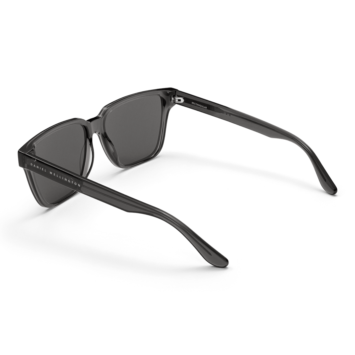 Rectangular Bio-Acetate Grey sunglasses with a transparent grey frame, dark lenses, and Daniel Wellington branding on the arm, shown from a rear angle.
