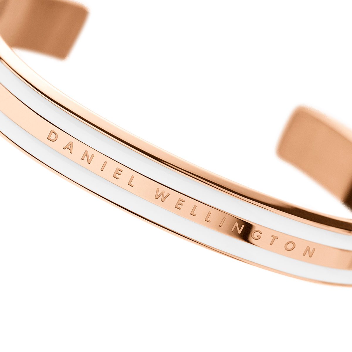 Close-up of the Emalie Bracelet Satin White Rose Gold, showing the engraved Daniel Wellington logo on the rose gold and satin white enamel cuff.