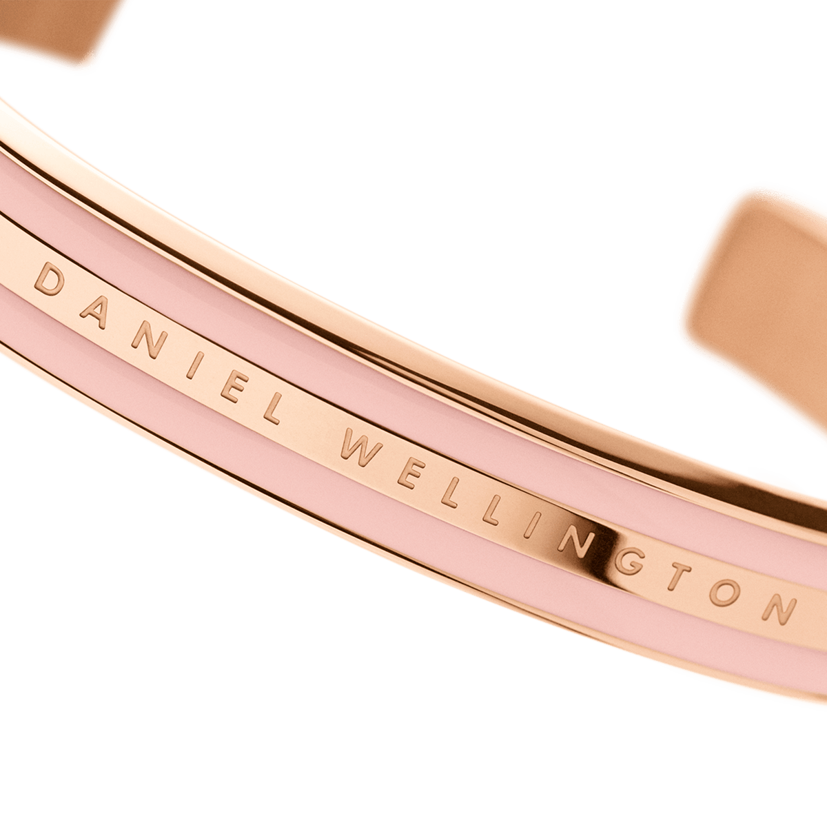Close-up of the Daniel Wellington Emalie Bracelet in rose gold with a dusty rose enamel inlay and engraved logo detail.