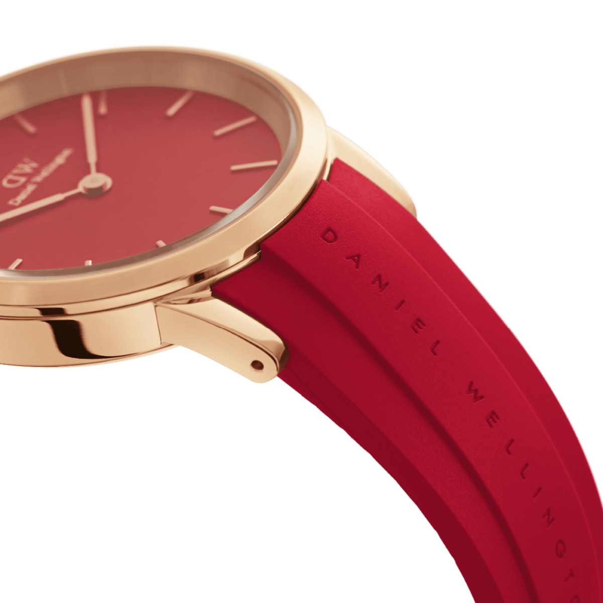 Close-up of the Daniel Wellington Iconic Motion Ruby watch showing the rose gold case, bold red dial, and embossed ruby red FKM rubber strap.