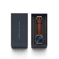 Classic St Mawes Arctic Rose Gold watch presented in a sleek Daniel Wellington gift box, featuring a blue sunray dial, rose gold case, and brown leather strap with matching buckle. The elegant packaging highlights the watch’s suitability for gifting and special occasions.
