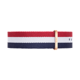 Nato-style watch strap in deep navy, white, and red stripes, finished with a rose gold buckle for a refined, modern look. The high-quality polyester material offers both durability and comfort, ideal for daily wear.