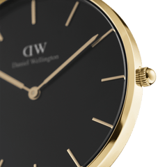 Close-up of Petite Evergold women’s watch with gold case, black minimalist dial, and gold hour markers by Daniel Wellington.