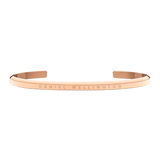 Slim rose gold Daniel Wellington cuff bracelet with engraved logo, minimalist open design, polished stainless steel finish.