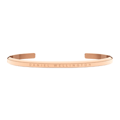 Slim rose gold Daniel Wellington cuff bracelet with engraved logo, minimalist open design, polished stainless steel finish.