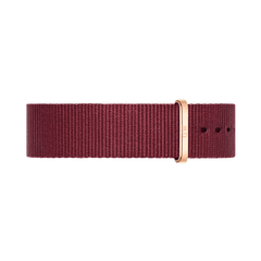 Deep ruby red polyester NATO-style watch strap with a polished rose gold buckle, featuring multiple adjustment holes for a secure and comfortable fit.