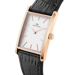 Rectangular rose gold watch with a white minimalist dial, slim hour markers, and a black crocodile-embossed leather strap.