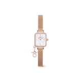 Rose gold women’s watch with a rectangular crystal-framed case, white mother of pearl dial, and a mesh strap featuring a sparkling zodiac charm. The petite and elegant design highlights refined details and a personal touch.
