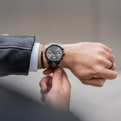A man wearing the Classic Ring Graphite by Daniel Wellington on his right hand, styled with a matching graphite watch and bracelet for a coordinated, modern look.