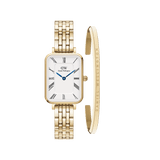 Rectangular gold watch with a five-link bracelet, white dial featuring Roman numerals and blue hands, paired with a slim gold cuff bracelet engraved with Daniel Wellington branding.