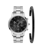 Silver chronograph watch with a black dial and stainless steel link strap, paired with a slim, polished silver cuff bracelet featuring subtle Daniel Wellington branding. The set showcases a modern, minimalist design ideal for both casual and formal wear.