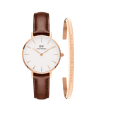 Petite St Mawes watch with a white dial, rose gold markers, and a brown leather strap, paired with a slim rose gold cuff bracelet engraved with Daniel Wellington branding.