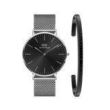 Sleek silver mesh strap watch with a black dial, paired with a minimalist silver bracelet featuring subtle Daniel Wellington branding, both crafted in polished stainless steel for a refined and timeless look.