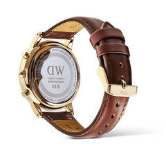 Rear view of the Daniel Wellington Iconic Chronograph St Mawes Arctic Panda Gold watch, showing the engraved stainless steel case back, gold pin buckle, and brown genuine leather strap.