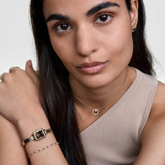 Woman wearing Audrey Necklace Tiger Eye Gold with domed Tiger Eye pendant and cubic zirconia, styled for everyday elegance.