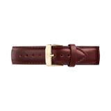 Brown leather watch strap with a tapered silhouette, featuring contrast stitching and a polished gold pin buckle engraved with the Daniel Wellington logo. The strap showcases a smooth finish and quick-release connector for easy attachment.