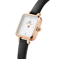 Close-up of the Quadro Mini Sheffield Rose Gold watch showing its rectangular rose gold case, minimalist white dial, and slim black leather strap.