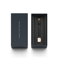 Quadro Mini Sheffield Rose Gold watch with a rectangular rose gold case and black leather strap, elegantly presented in a dark Daniel Wellington gift box.