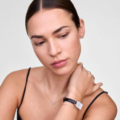 Model wearing Mirelle Infinity Earring Rose Gold, styled with a matching infinity necklace, bracelet, and a rose gold-accented watch, highlighting the delicate pavé set cubic zirconia and minimalist design.